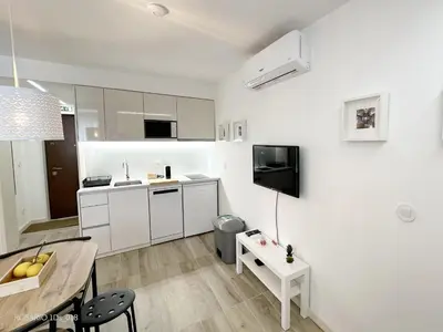 a kitchen with white cabinets and a table in a room at ROSARIO 1Ds by rosario inn porto in Porto