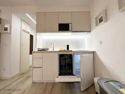 a kitchen with white cabinets and a sink at ROSARIO 1Ds by rosario inn porto in Porto