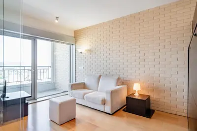a living room with a chair and a brick wall at VIVA Stadium Residence Studios in Porto