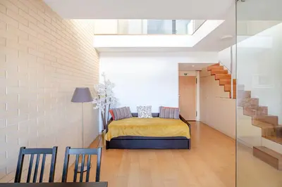 a bedroom with a bed in a white brick wall at VIVA Stadium Residence Studios in Porto