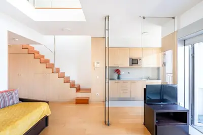 a living room with a bed and a staircase at VIVA Stadium Residence Studios in Porto