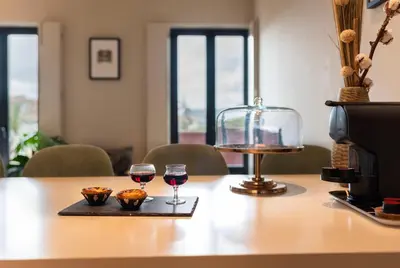 a table with two glasses of wine and muffins on it at Elegant Duplex Apt in Downtown by Lisbeyond in Porto