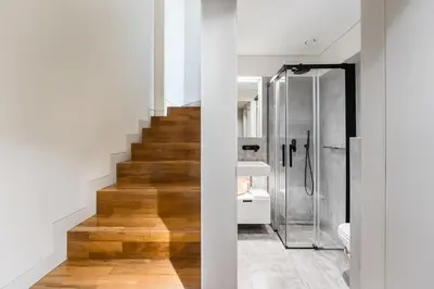 a bathroom with a glass shower and a staircase at Elegant Duplex Apt in Downtown by Lisbeyond in Porto