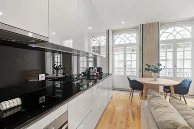 a kitchen with black and white appliances and a table at Almada Prime - Live in Porto in Porto