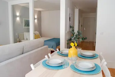 a dining room with a table and a couch at Almada Prime - Live in Porto in Porto