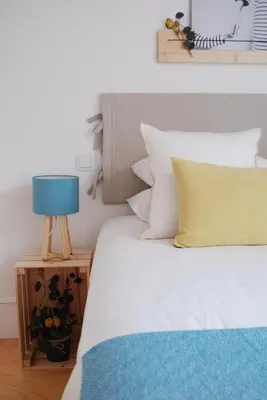 a bed with a blue lamp on a night stand at Almada Prime - Live in Porto in Porto