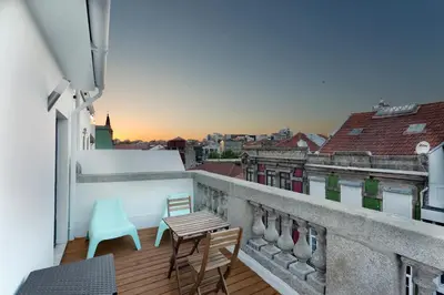 a balcony with chairs and tables on a building at Fernandes Tomas Rooftop in Porto