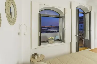a bedroom with a window with a view of a city at Fernandes Tomas Rooftop in Porto