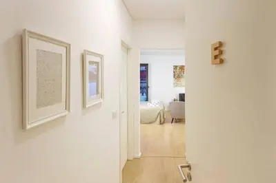 a white hallway with two pictures on the walls at Fernandes Tomas Rooftop in Porto