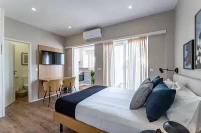 a bedroom with a large bed with blue pillows at Nomad's Easy Stay - Studio Lounge Casa da Musica in Porto