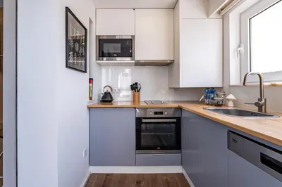 a kitchen with white cabinets and a sink at Nomad's Easy Stay - Studio Lounge Casa da Musica in Porto