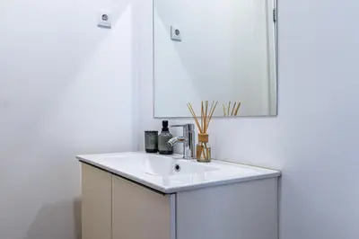 a bathroom with a white sink and a mirror at Nomad's Easy Stay - Studio Lounge Casa da Musica in Porto