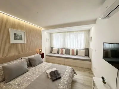 a bedroom with a bed and a window with a couch at ROSARIO 1Dn by rosario inn porto in Porto