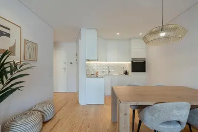 a kitchen and dining room with a wooden table and chairs at GuestReady - Comfortable stay in Porto in Porto