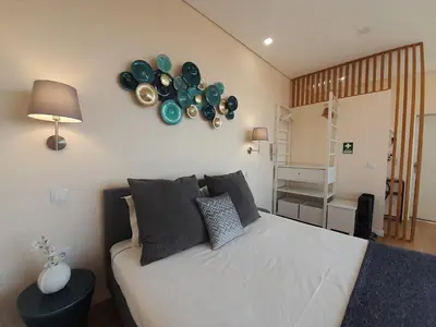 a bedroom with a bed with plates on the wall at Vista Bolhão Studio in Porto