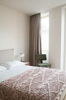 a bedroom with a bed and a chair and a window at Corujeira Apartments by MyALPlace in Porto