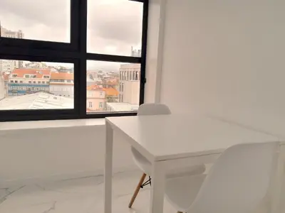 a white table and chair in front of a window at VB Porto Studio II in Porto