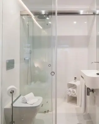 a bathroom with a shower and a toilet and a sink at Bandeiras in Porto