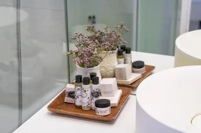 a shelf with cosmetics and flowers in a bathroom at Bandeiras in Porto