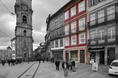 a group of people walking down a street with a clock tower at YOUROPO - Torre in Porto
