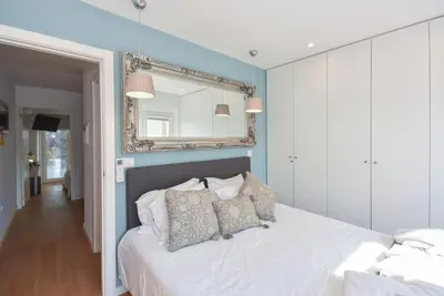a bedroom with a white bed with a mirror on the wall at Miradouro 25 - Porto centre - luxury epic views in Porto
