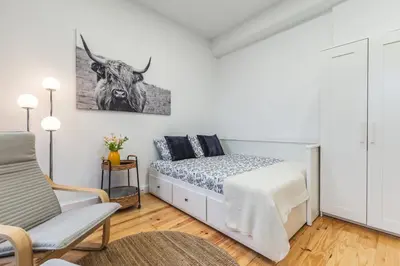 a bedroom with a bed with a cow picture on the wall at Charming Studio with Garden in Porto in Porto