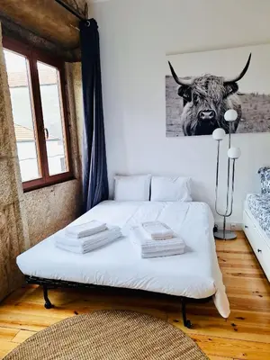 a bedroom with a bed with a picture of a bull on the wall at Charming Studio with Garden in Porto in Porto
