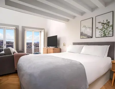 a bedroom with a large white bed and a tv at Limehome Porto Rua 31 de Janeiro in Porto