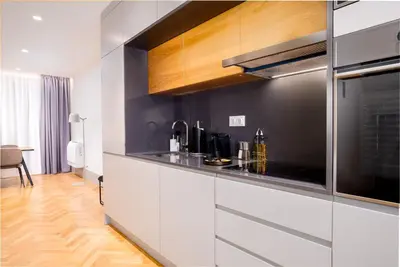 a kitchen with white cabinets and a black wall at Limehome Porto Rua 31 de Janeiro in Porto