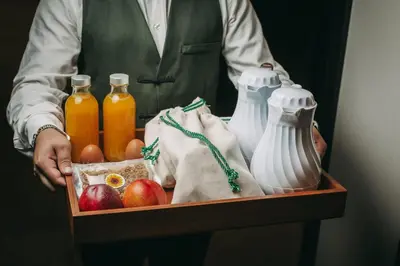 a person holding a tray of food and bottles of juice at Hotels 705 Porto Prime Home in Porto