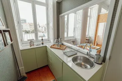 a kitchen with a sink and two windows at Downtown Bolhão by Hosty in Porto