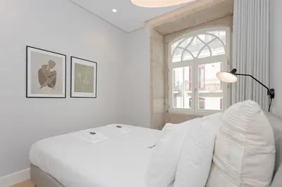 a white bedroom with a bed and a window at Liiiving in Porto - Luxury Design Apartments in Porto