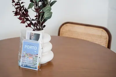a table with a vase with a plant and a book at GuestReady - Little Johnny in Porto