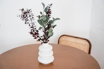 a white vase with flowers in it on a table at GuestReady - Little Johnny in Porto