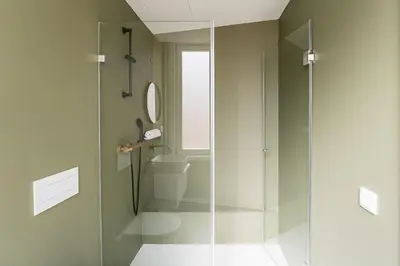 a bathroom with a glass shower with a toilet at GuestReady - Little Johnny in Porto