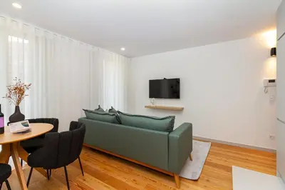 a living room with a green couch and a table at GuestReady - Dream Vitoria Apartment in Porto