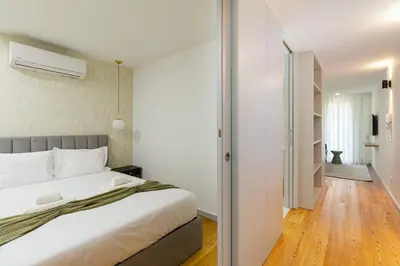 a bedroom with a large bed and a hallway at GuestReady - Dream Vitoria Apartment in Porto