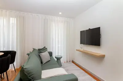 a living room with a couch and a tv on a wall at GuestReady - Dream Vitoria Apartment in Porto