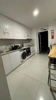 a kitchen with a sink and a washing machine at Owls Hostel Ribeiro in Porto