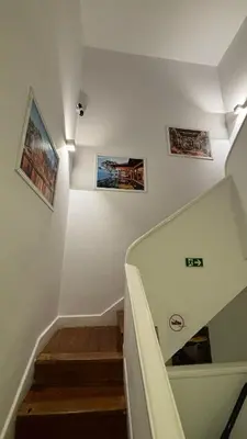 a staircase with three pictures on the wall at Owls Hostel Ribeiro in Porto