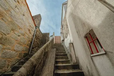 an alley with stairs between two buildings with a red window at Modern Studio by Hosty in Porto