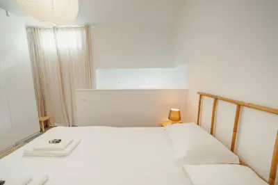 a white bedroom with a bed and a mirror at Modern Studio by Hosty in Porto