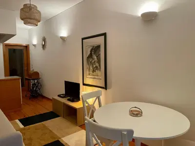 a dining room with a white table and a computer at Douro River Charming Flats in Porto