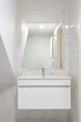 a white bathroom with a sink and a mirror at Host Wise - Santa Catarina Cosy Downtown in Porto