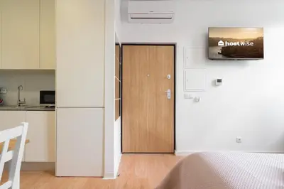 a wooden door in a white room with a kitchen at Host Wise - Santa Catarina Cosy Downtown in Porto