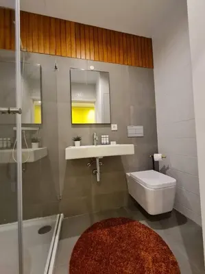 a bathroom with a sink and a toilet and a mirror at INSOLI I Porto by Apartments2Stay in Porto