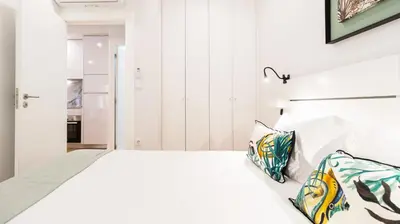 a white bedroom with a bed with a white headboard at Porto River Flat w/ Patio by LovelyStay in Porto