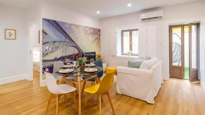 a living room with a table and chairs and a couch at Porto River Flat w/ Patio by LovelyStay in Porto