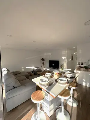a living room with a couch and a table with stools at Fantástico T3 Porto - 6 Pessoas in Porto