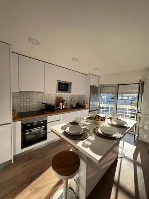 a kitchen with white cabinets and a black oven at Fantástico T3 Porto - 6 Pessoas - Novo in Porto